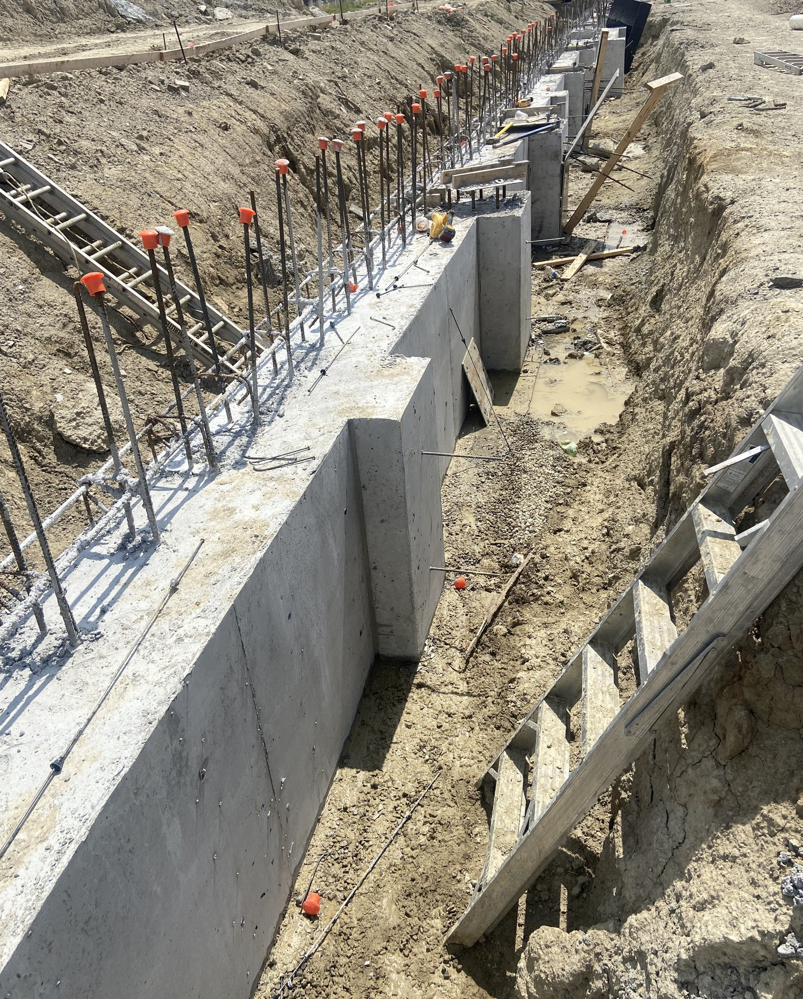 Concrete foundation wall with projecting reinforcing steel