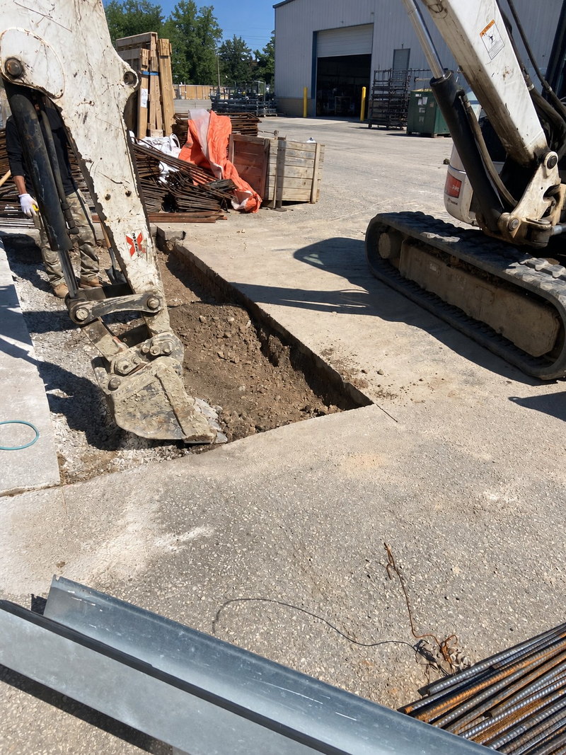 Excavated concrete apron area beside an overhead door