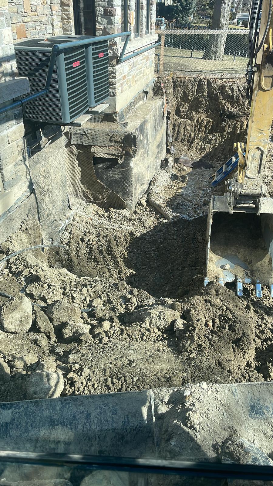 Excavator working beside an existing building